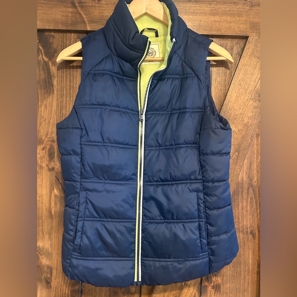 Authentic American Heritage blue puffer vest with yellow lining, size small.
